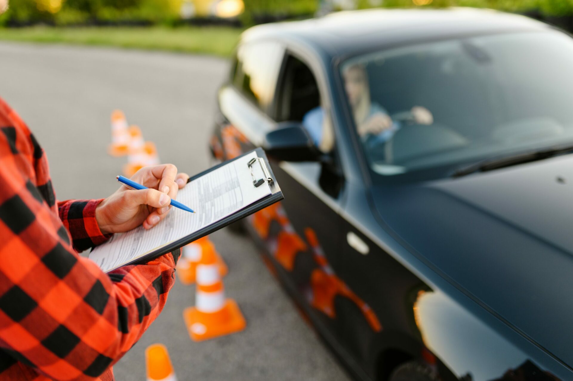 Instructor with checklist and woman in car, exam